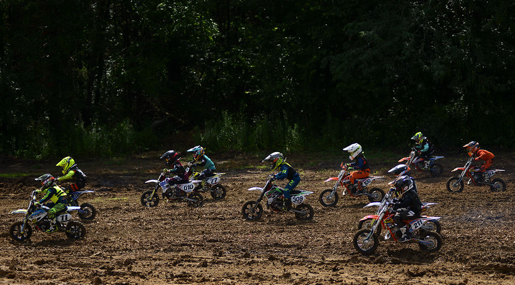 Youth motocross participants take off from just outside of their starting positions